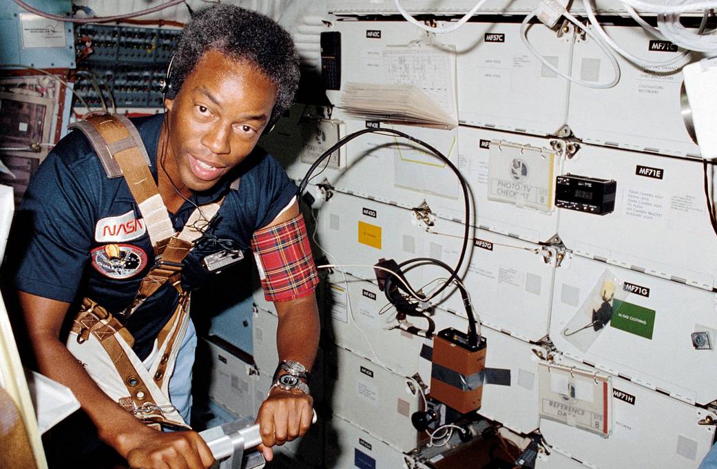 Guion S. Bluford assists with a medical test that required the use of a treadmill exercising device designed by the STS-8 medica