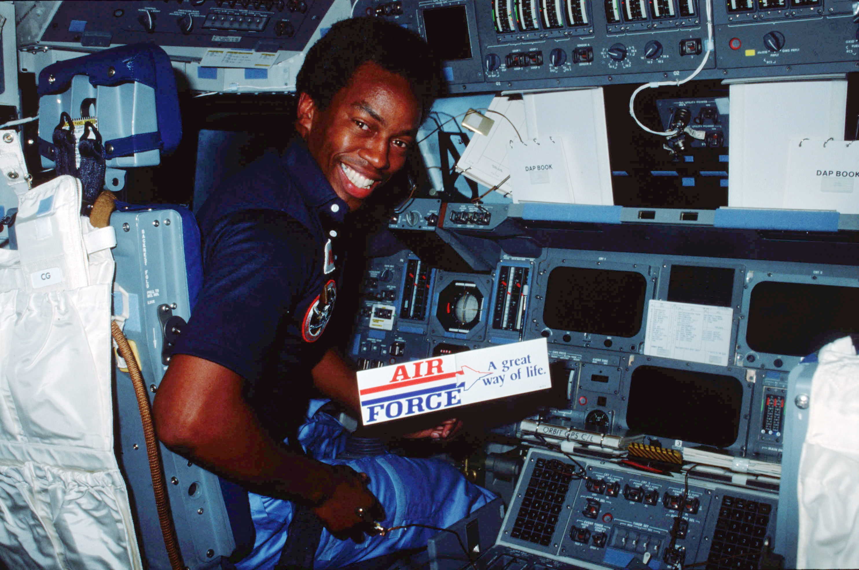 Guy Bluford on STS-8 poses with a Air Force bumper ssticker