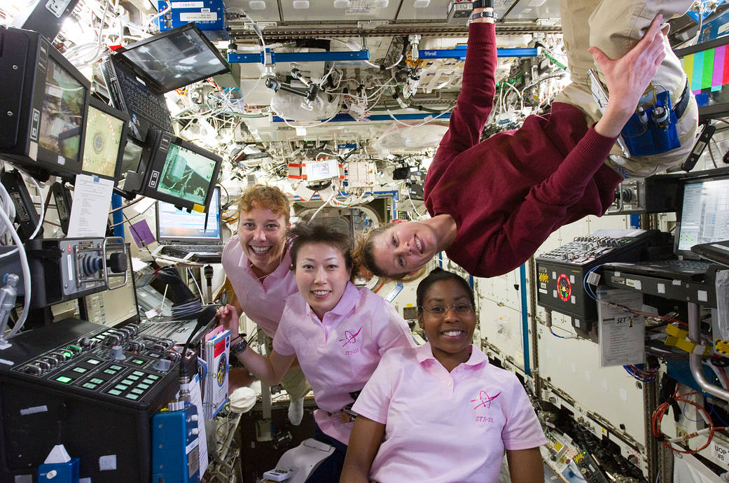 NASA astronauts and JAXA astronaut at work inside International Space Station's Robotics Workstation