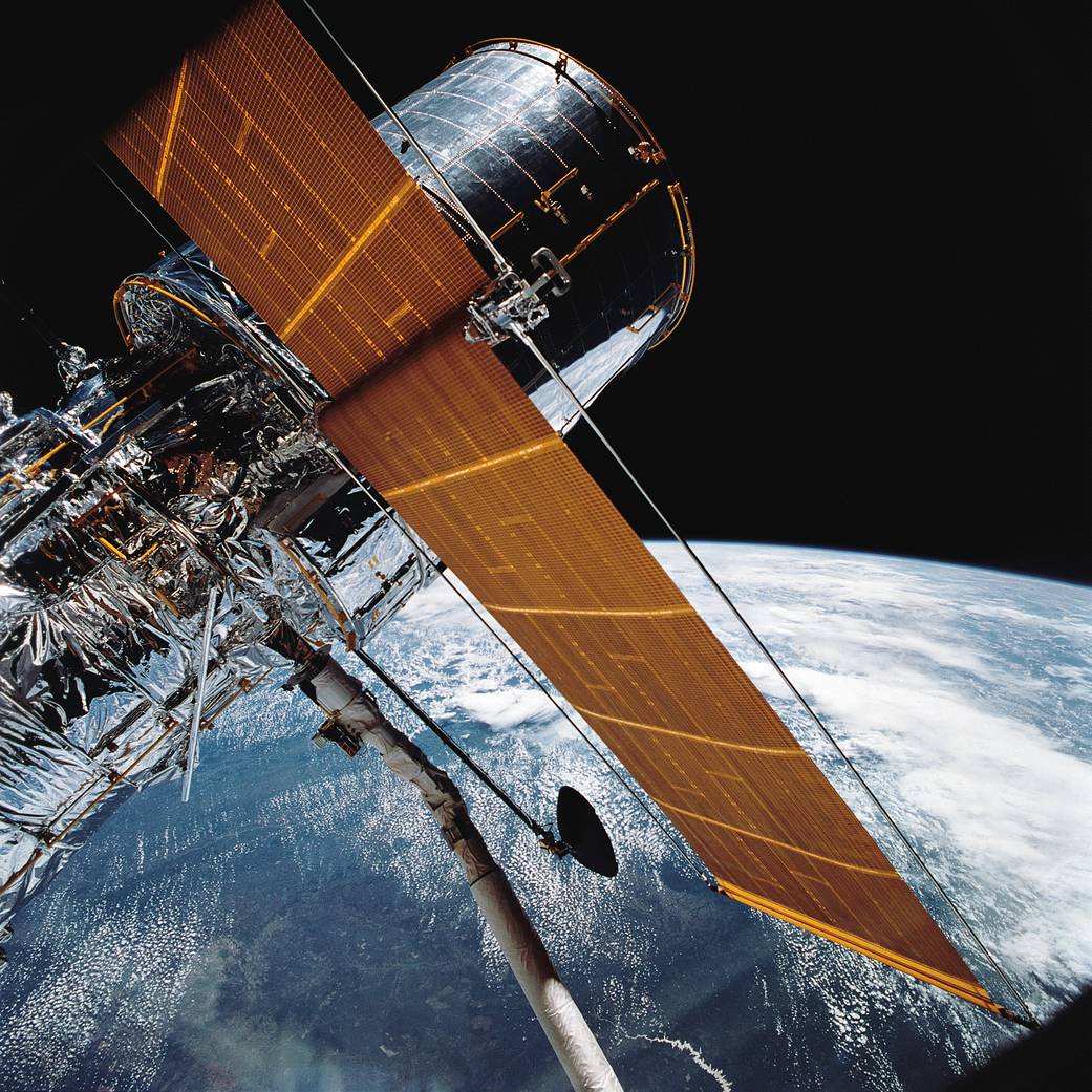 Hubble Space Telescope in space after deployment with Earth below