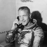 Scott Carpenter in spacesuit after mission splashdown speaks on telephone