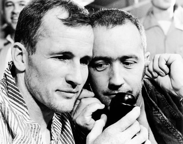 Closeup of two astronauts as they listen to telephone
