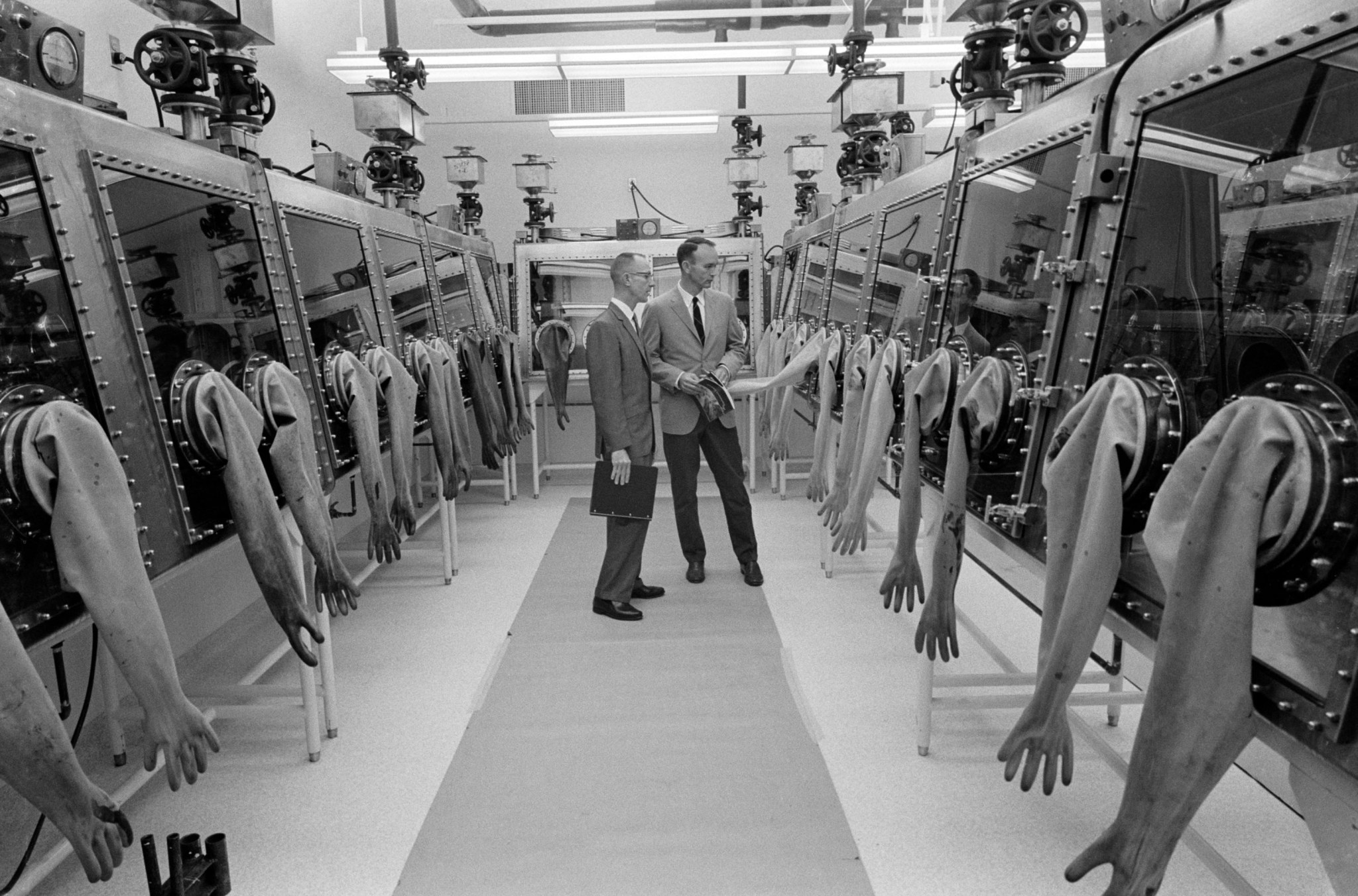 Astronaut Michael Collins on the right and Richard Wright on the left during tour of Lunar Receiving Lab (LRL) at MSC. (1967)