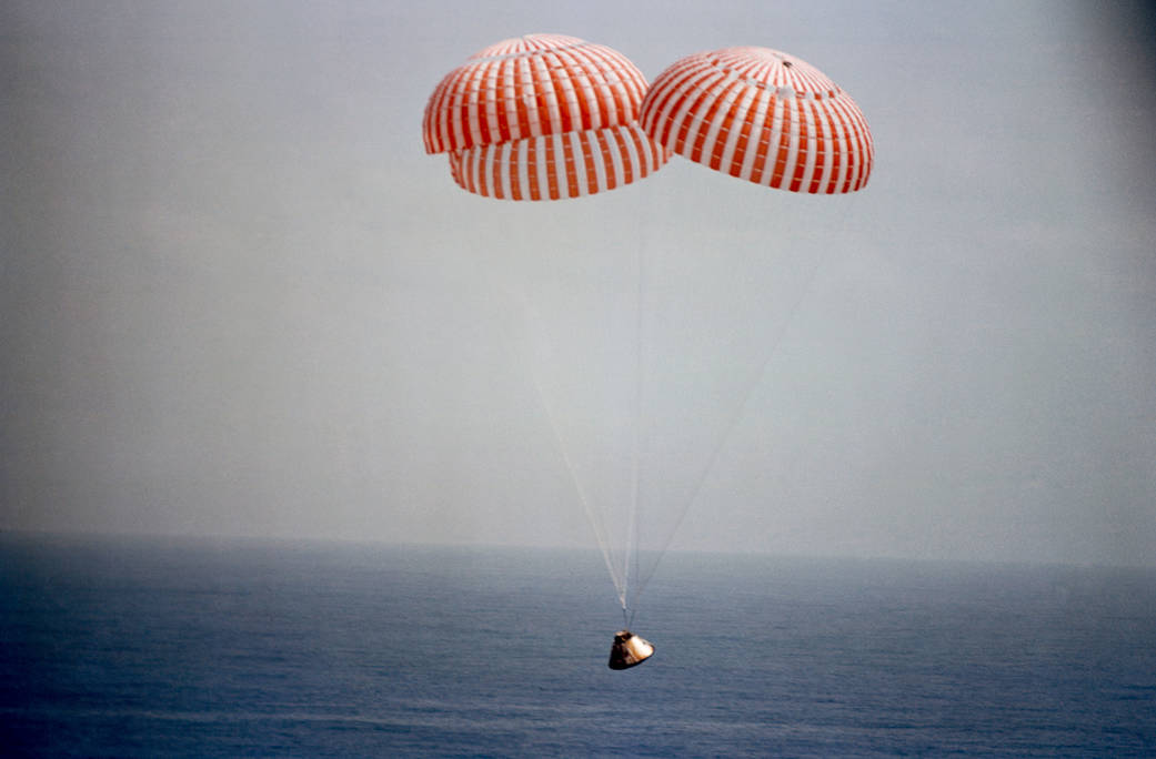 Apollo capsule with parachutes deployed descends to splashdown