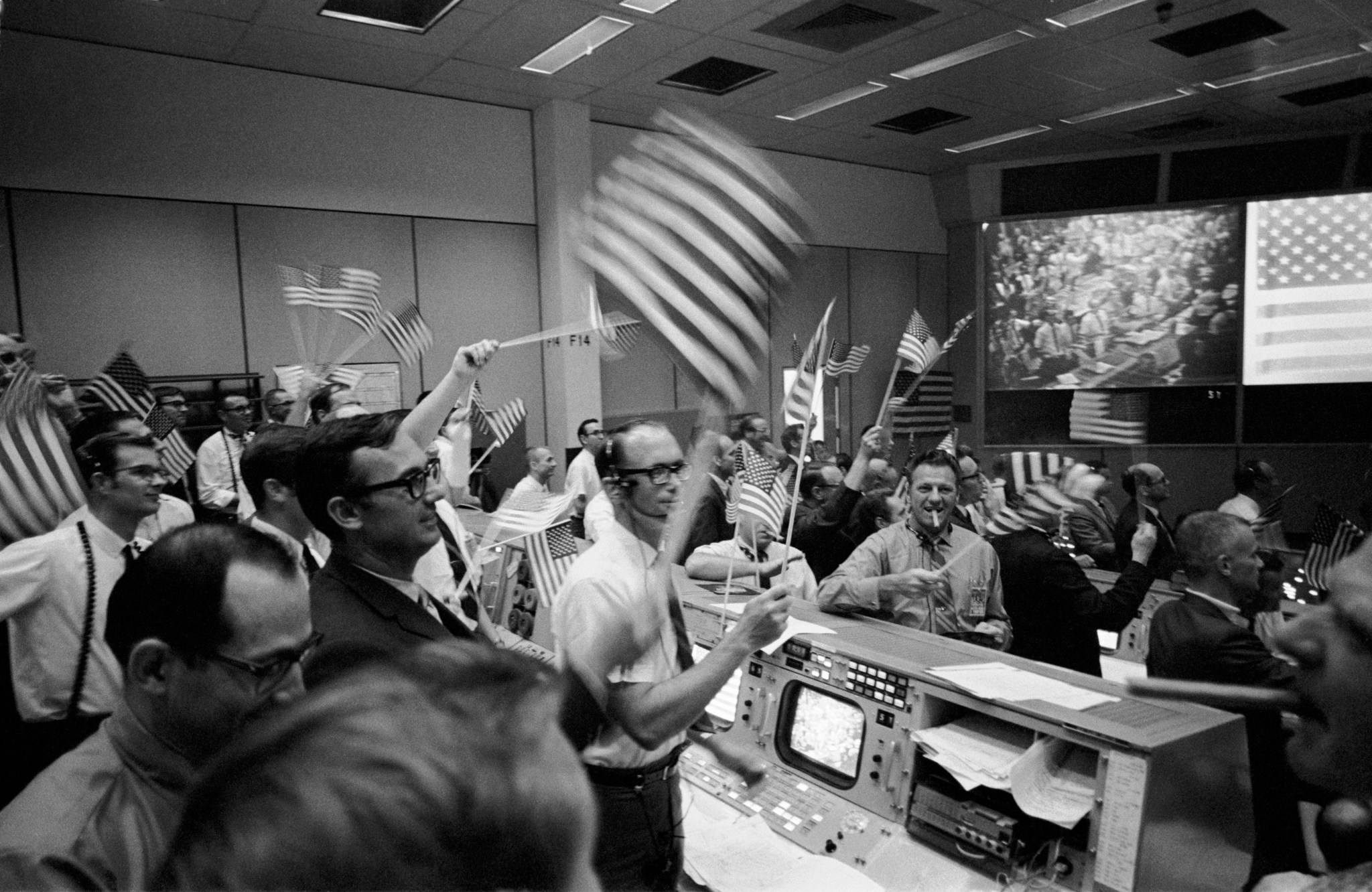 Overall view of the Mission Operations Control Room in the Mission Control Center,  Manned Spacecraft Center showing the flight controllers celebrating the successful conclusion of the Apollo 11 lunar landing mission.