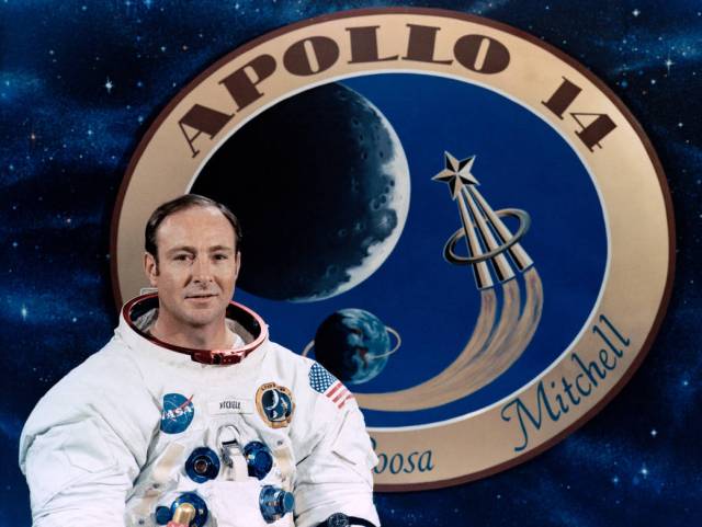 Official portrait of astronaut Edgar D. Mitchell with Apollo 14 insignia in background