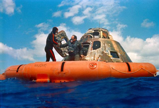 Astronaut Edgar D. Mitchell, lunar module pilot, is assisted out of the Command Module