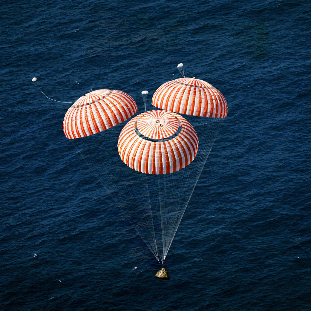 Capsule splashes down with three parachutes opened 