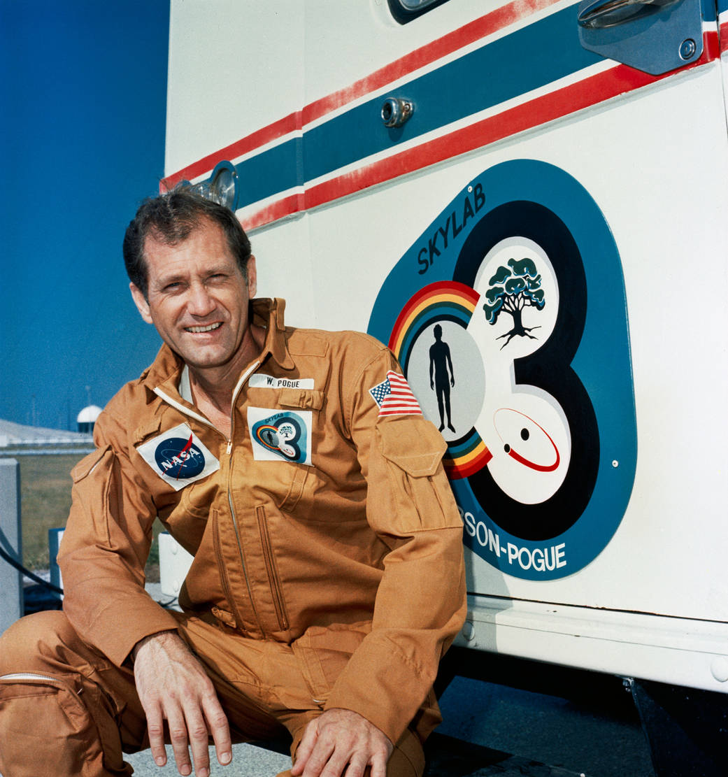 Astronaut William R. Pogue, pilot of the Skylab 4 mission, relaxes on the running board of the transfer van during a visit to th