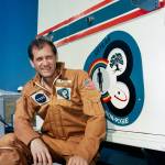 Astronaut William R. Pogue, pilot of the Skylab 4 mission, relaxes on the running board of the transfer van during a visit to th