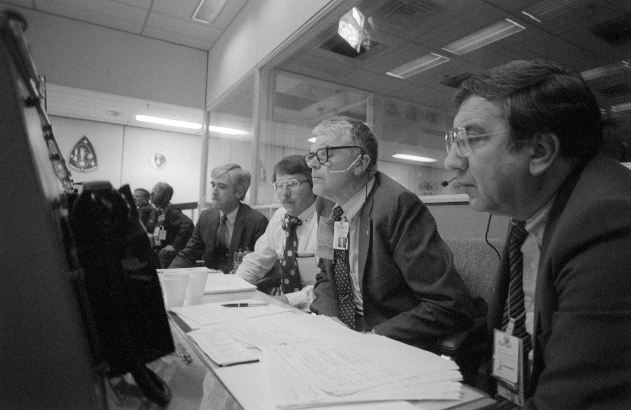 Sitting in front of a console in the Mission Operation Control Room during the STS-6 EVA are Milt Silveira, Special Assistant to the NASA Deputy Administrator, Hans Mark, who is sitting next to him.