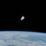 Spacewalking astronaut on untethered spacewalk surrounded by empty space with Earth below