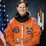 Portrait of Astronaut Kenneth S. Reightler Jr., in orange launch and entry suit.