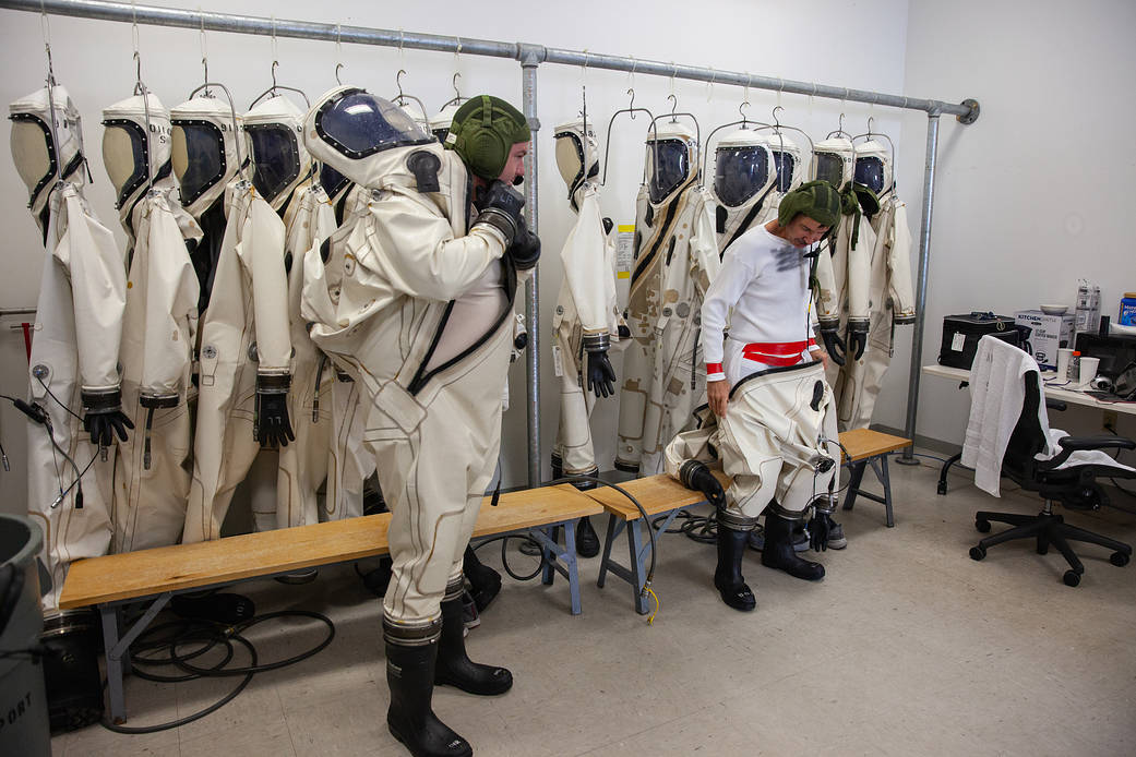 SCAPE operators practice putting on Self-Contained Atmospheric Protectice Ensemble suits at Kennedy Space Center in Florida.