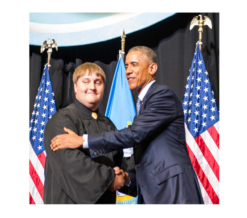 Space Grant student in Graduation Attire Shaking Hands with President Obama