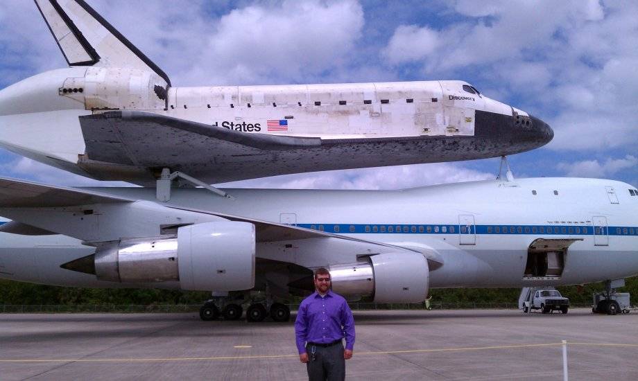 Michael Barth stands next to space shuttle Discovery at Kennedy Space Center
