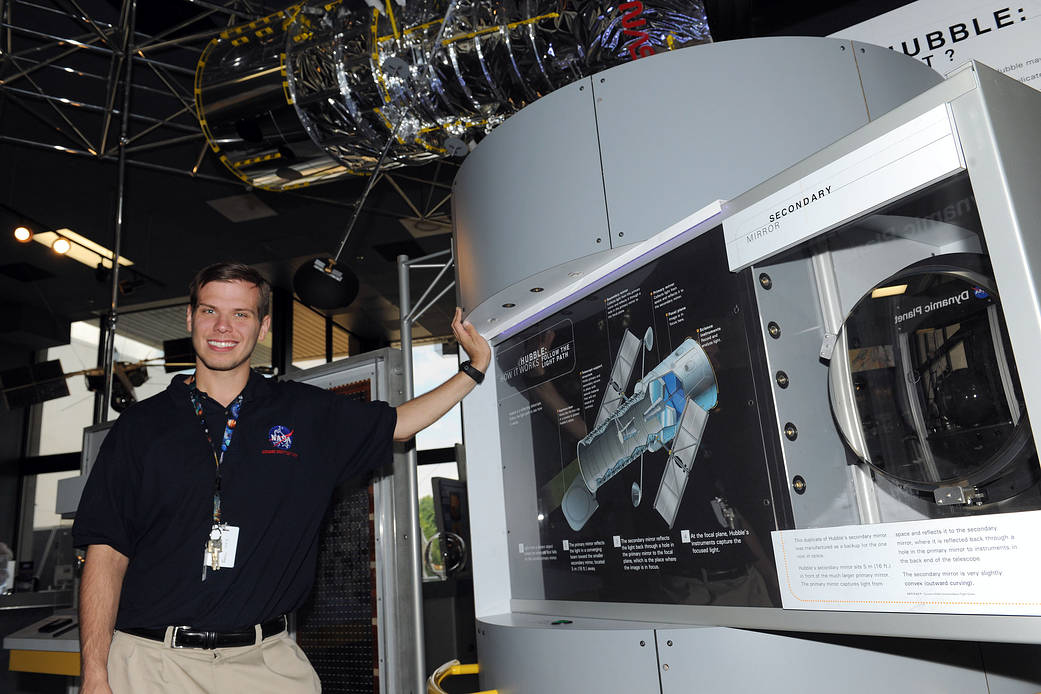Kentucky Space Grant student Nick Johnson stands in front of display at Goddard