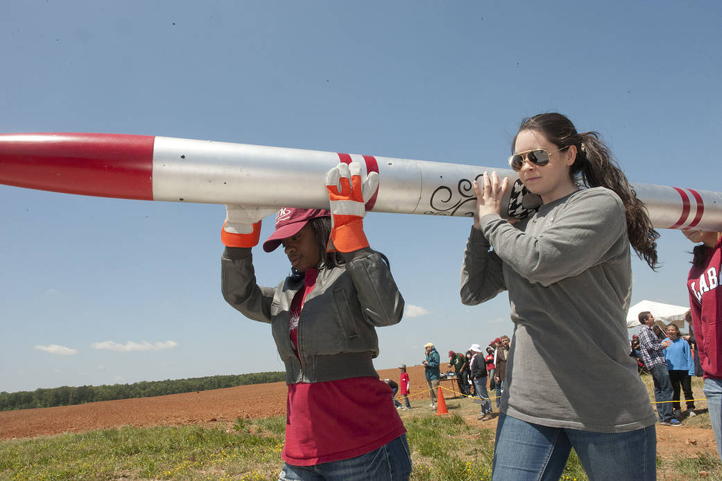 Girls carrying a rocket