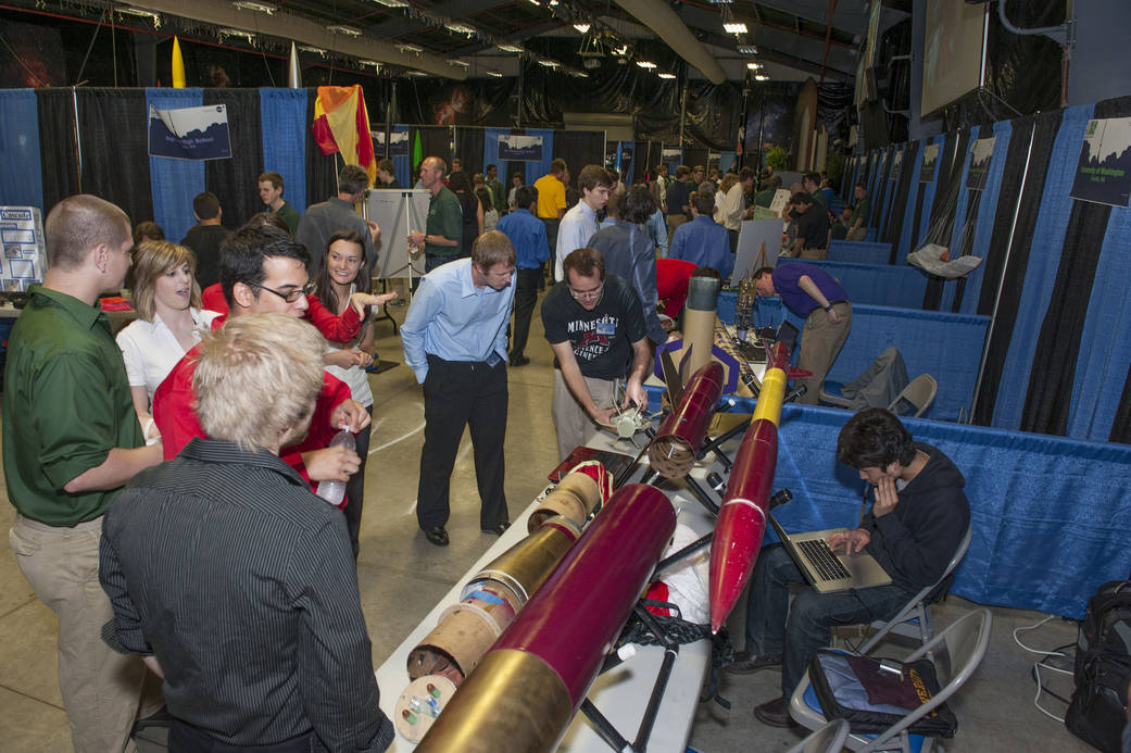 A group of people look at a team's rocket display