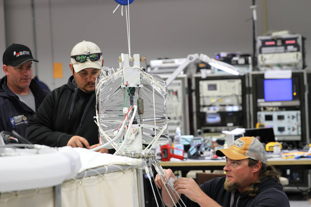 Team members install the ripstich to reduce shock load on the balloon