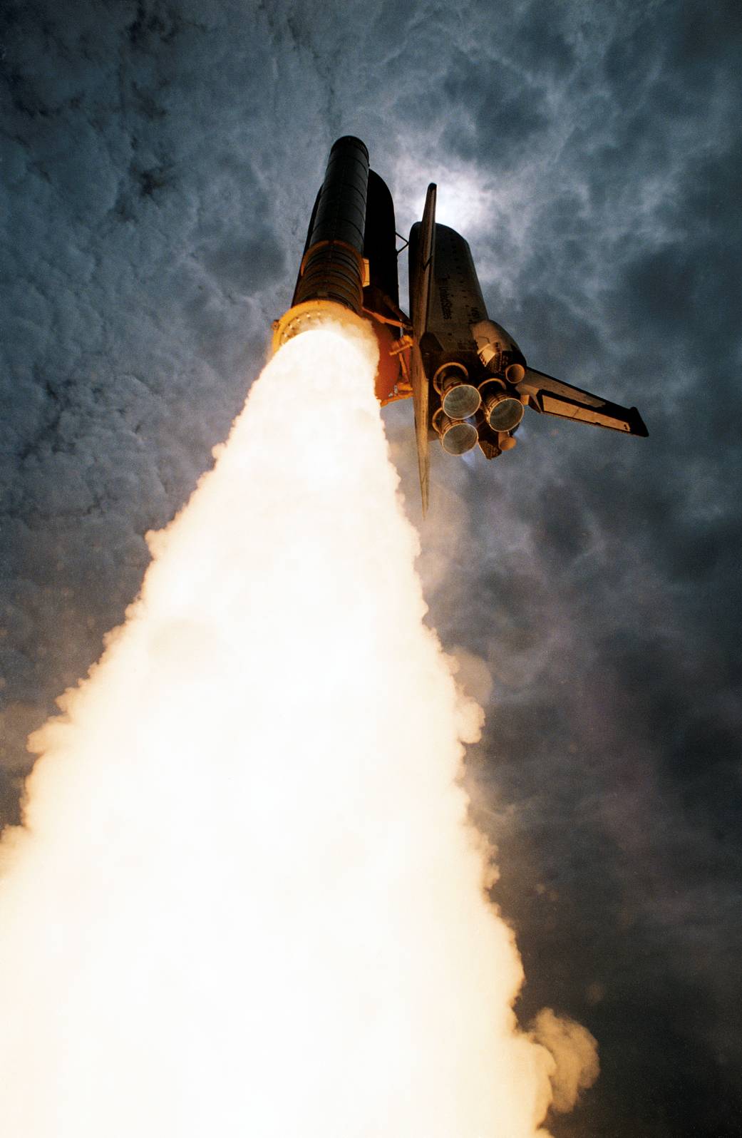 Shuttle launching upward to space, captured from angle on ground