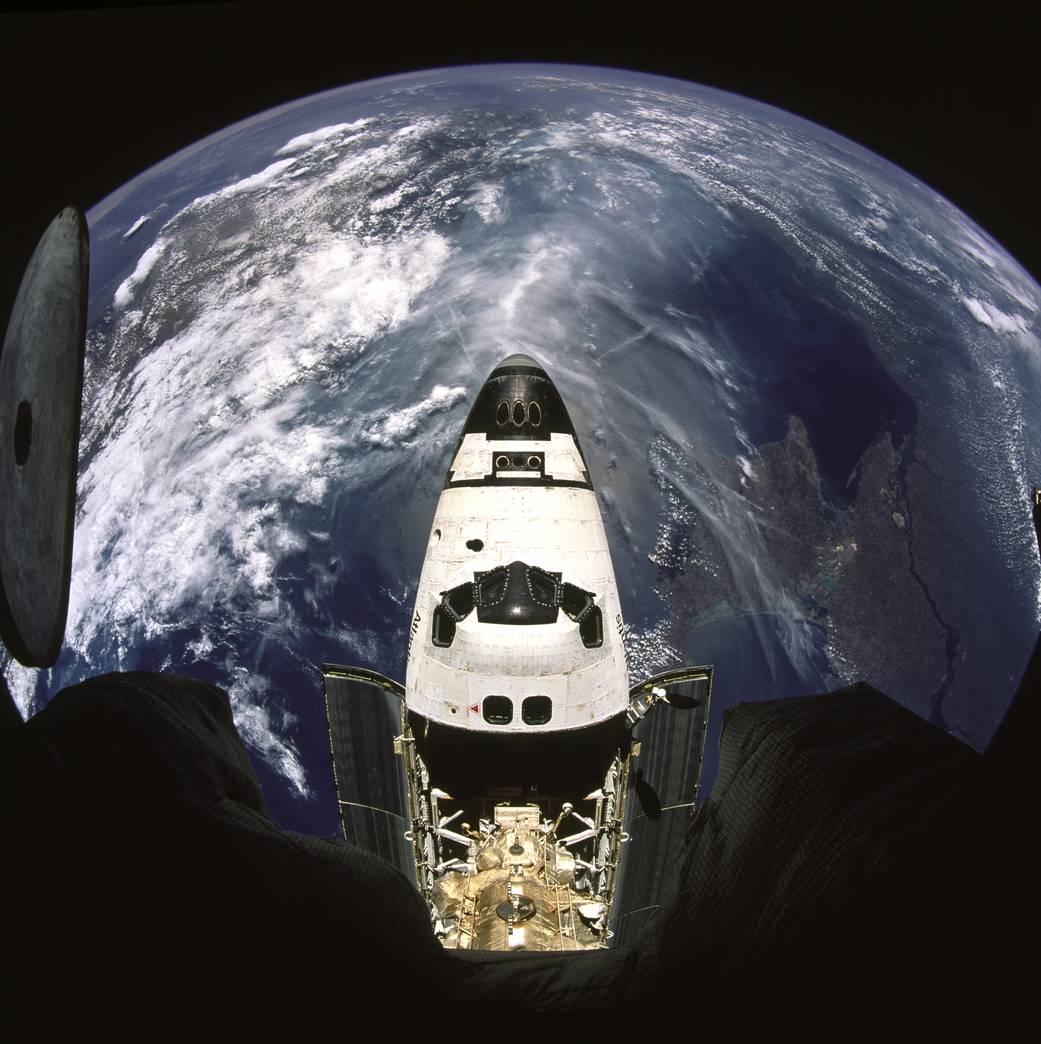 Fish-eye view of shuttle Atlantis taken from Russian Mir with Black Sea visible below