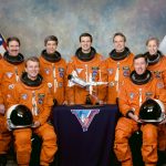 STS-81 official crew portrait in orange launch and entry suits.