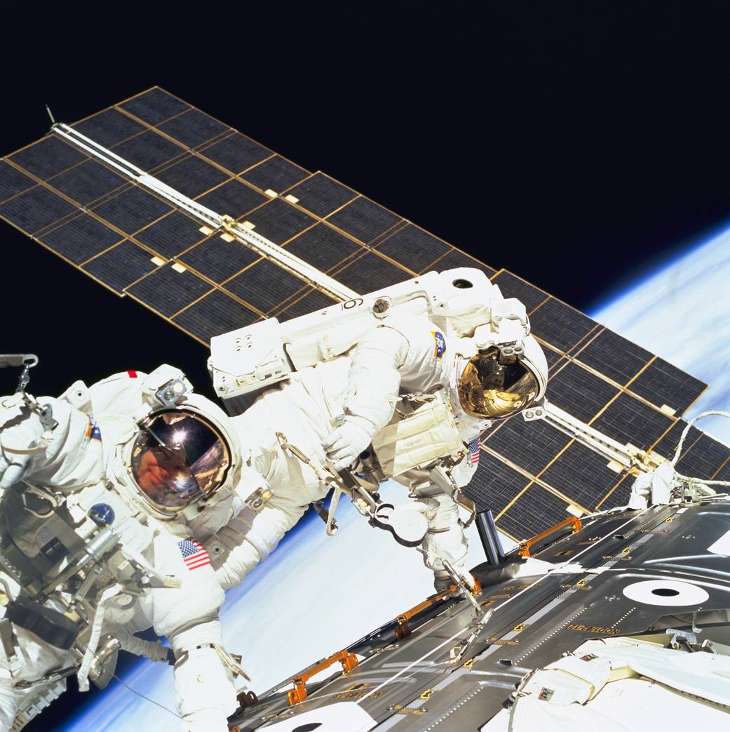 Two astronauts spacewalking outside the Zarya module of the space station