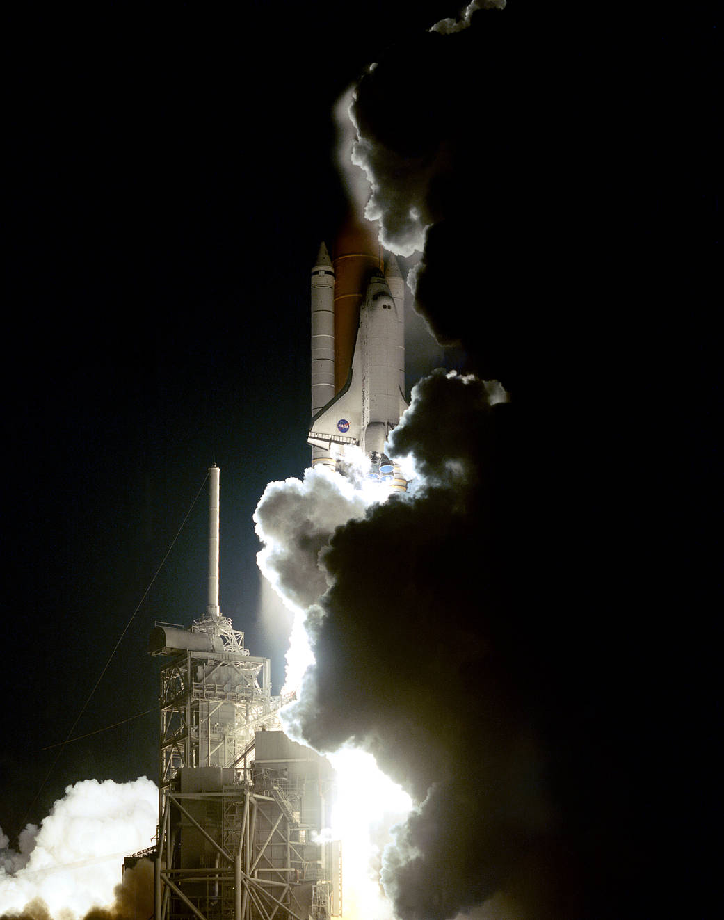Space shuttle lifts off from launchpad at night