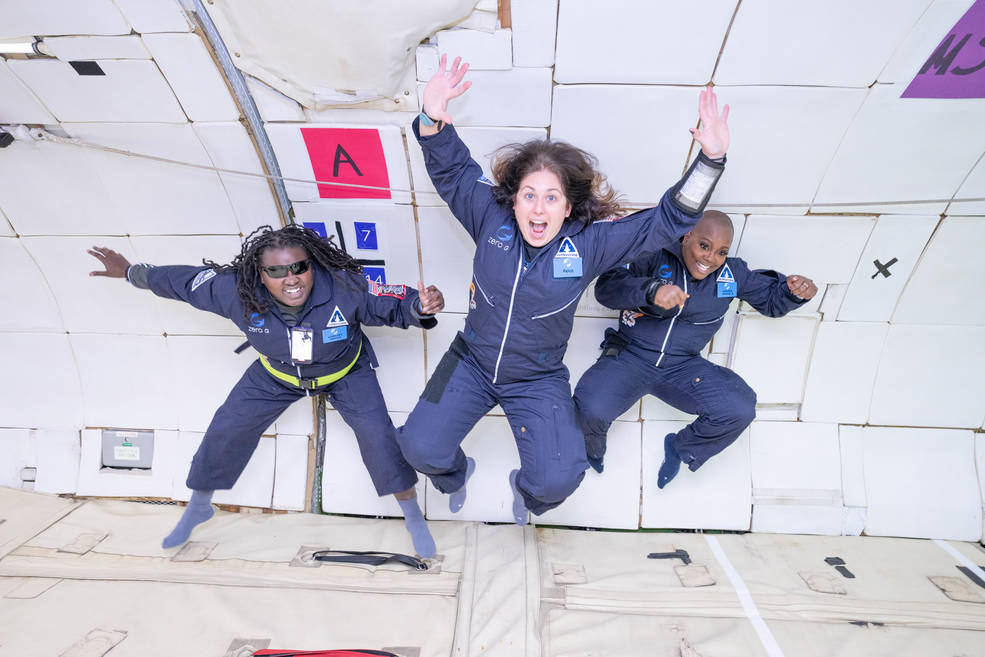 Three people jump in the air on a flight to promote disability inclusion. 