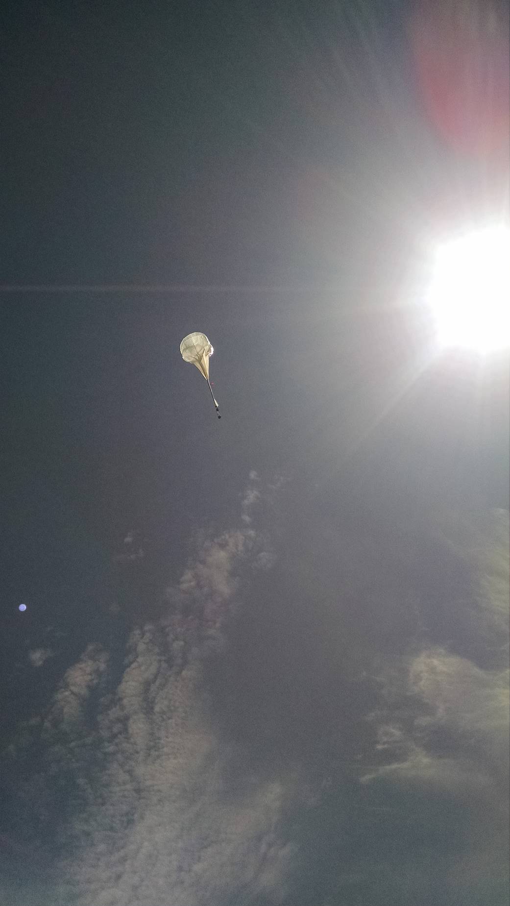 A Near Space Corporation high-altitude balloon is highlighted by the sun on a flight test.