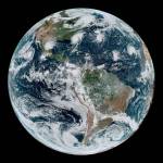 GOES-16 image of Earth showing four tropical storms in white, blue, green and orange colors.