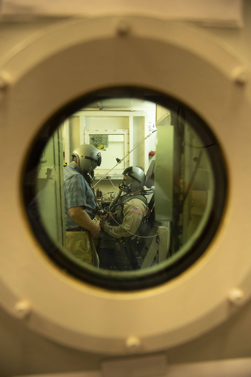 A KBR employee and a military test volunteer prepare for an altitude chamber flight that ensures the X-59 pilot’s safety at a variety of altitudes.