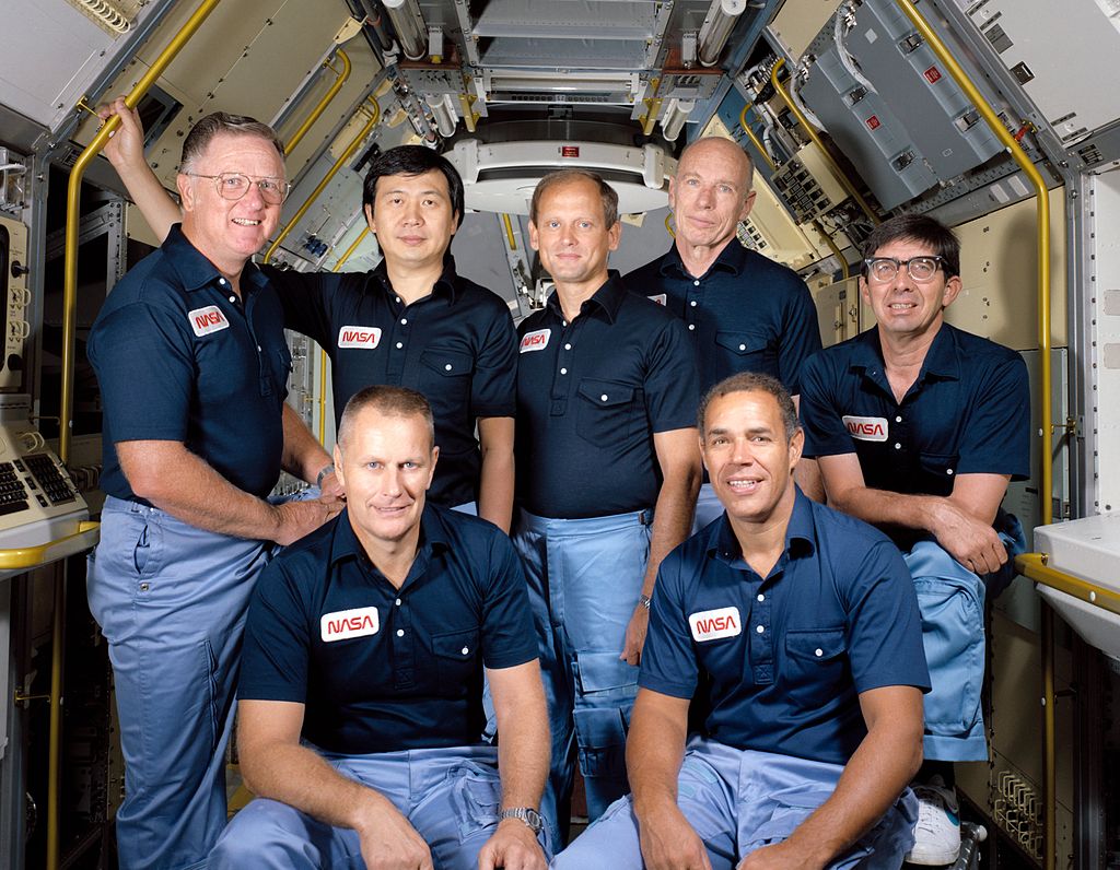 Seven crew members pose inside shuttle