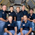 Seven crew members pose inside shuttle