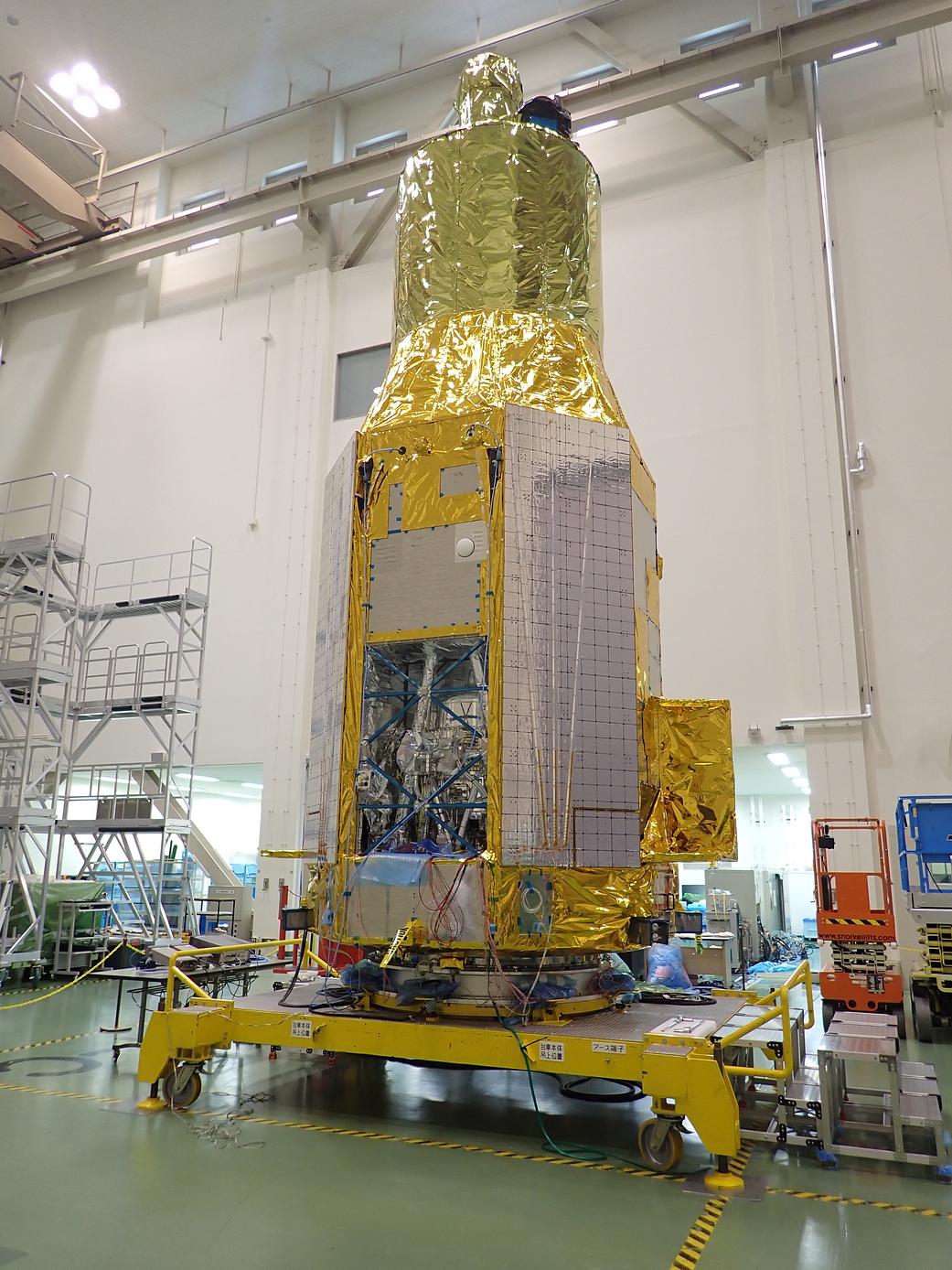 XRISM, covered in gold-colored insulation, stands ready at Japan's Tsukuba Space Center in May 2022 in preparation for tests. 