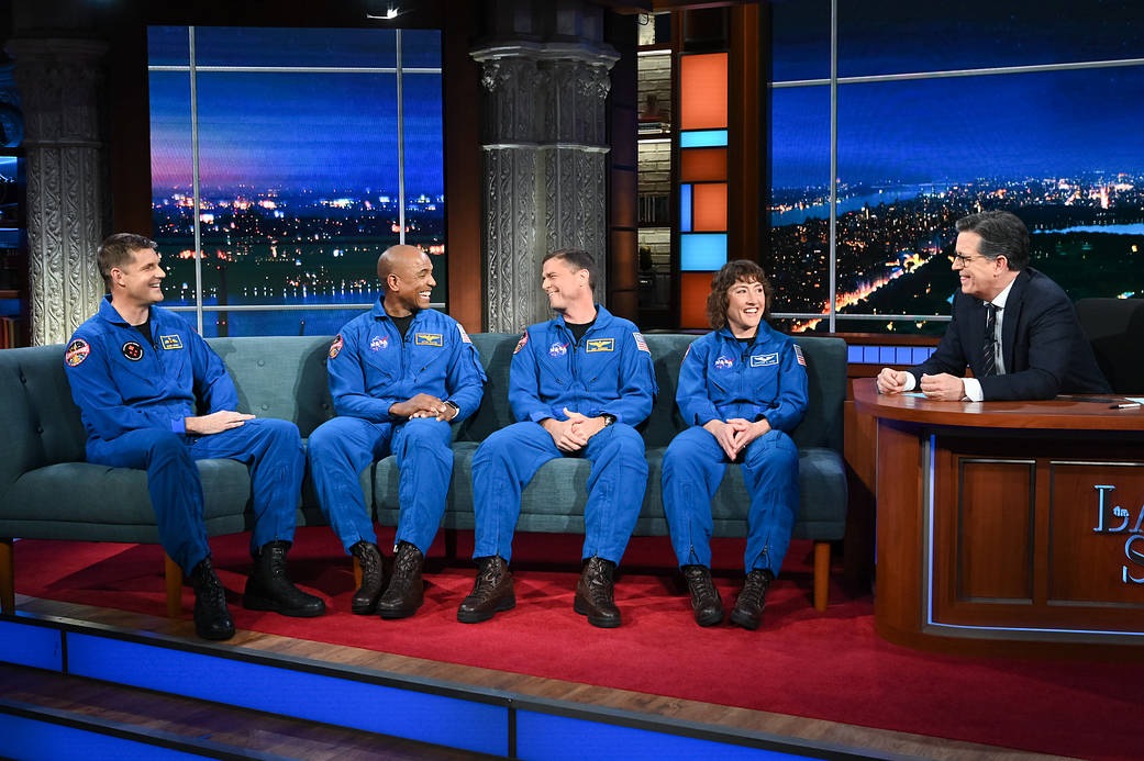From left, astronauts Jeremy Hansen, Victor Glover, Reid Wiseman and Christina Hammock Koch talk with television host Stephen Colbert on "The Late Show with Stephen Colbert" on April 5, 2023. 