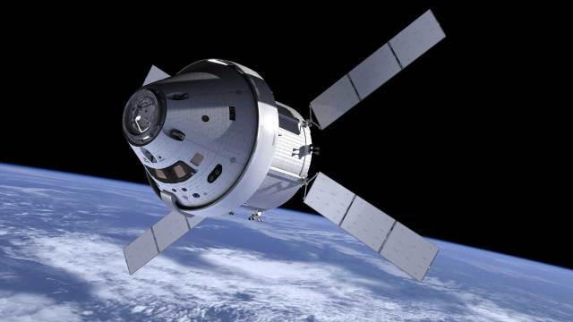 Artist illustration of Orion capsule with solar panels extended over a cloud coverd earth.