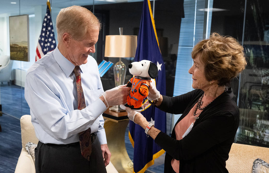 NASA Administrator Bill Nelson, left, is seen with Jeannie Schulz, widow of Peanuts gang creator Charles M. Schulz, right, holding the Artemis I Snoopy zero gravity indicator, Wednesday, April 5, 2023, during a visit to NASA Headquarters.