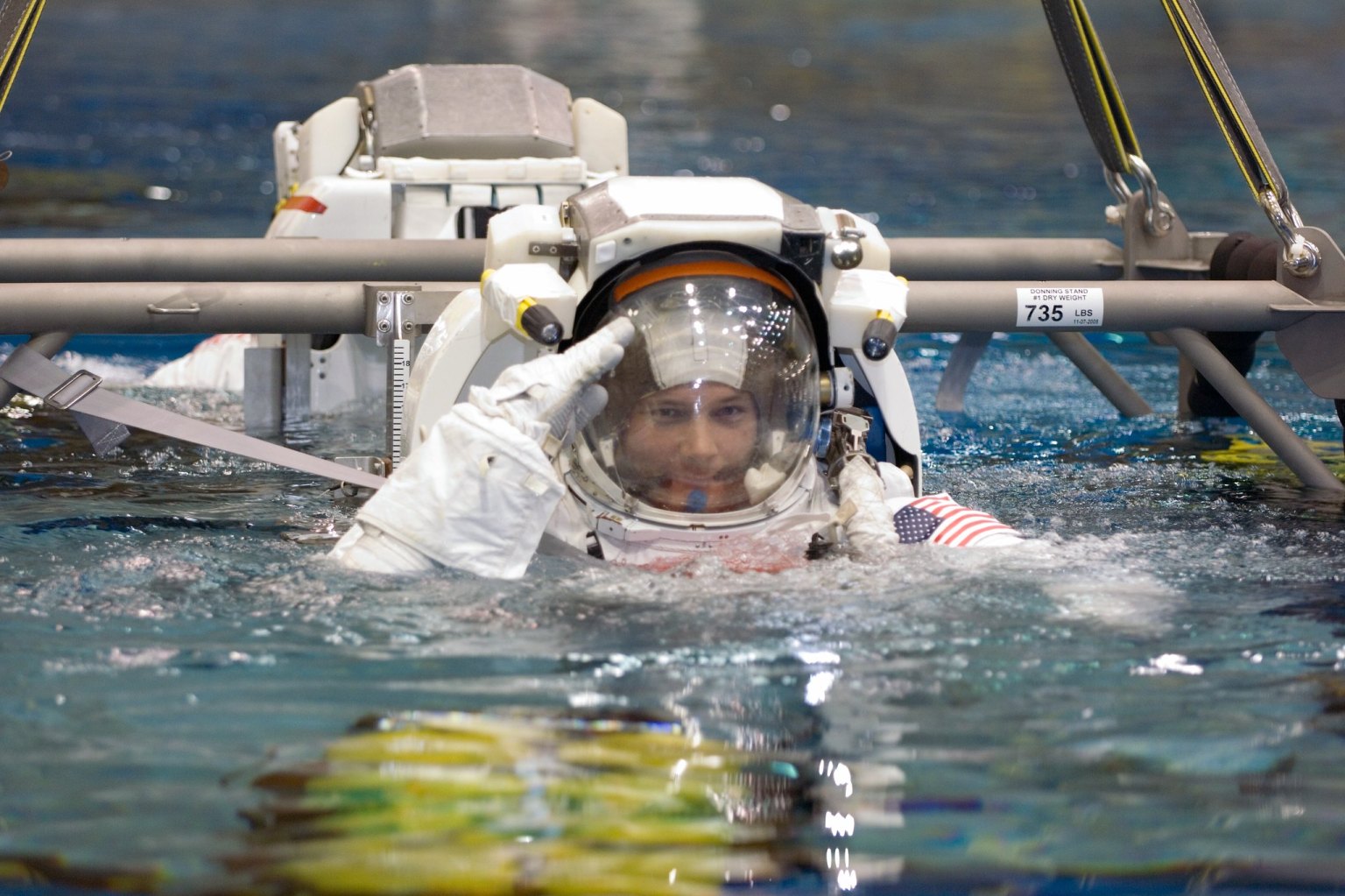 Astronauts Douglas H. Wheelock and Scott E. Parazynski (partially obscured), both STS-120 mission specialists, are about to be submerged in the waters of the Neutral Buoyancy Laboratory (NBL) near Johnson Space Center.
