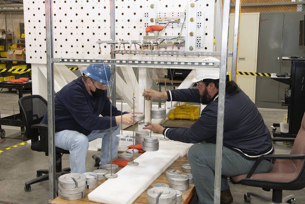 Aaron Rumsey and Beto Hinojos add weight to a model of the Transonic Truss-Braced Wing at NASA’s Armstrong Flight Research Center, in Edwards, California. 