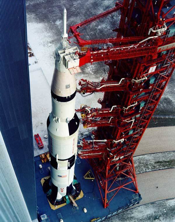 In this high-angle view at the Kennedy Space Center, the Saturn V rocket for the Apollo 12 mission rolls out of the Vehicle Assembly Building.