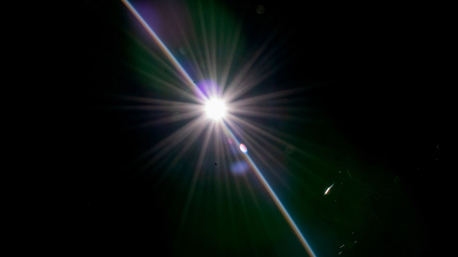 The last rays of an orbital sunset penetrate Earth's horizon in this photograph from the space station as it orbited off the coast of southern Argentina.