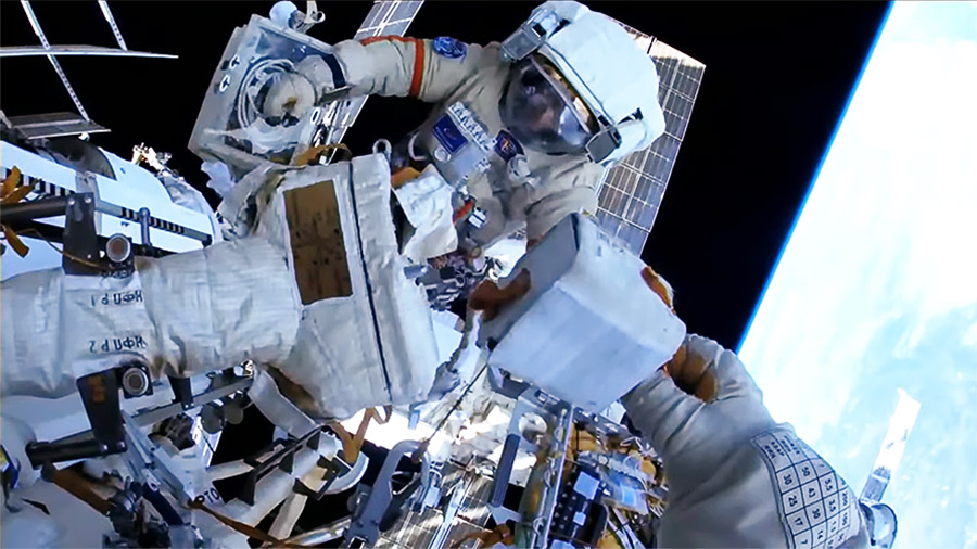 Cosmonaut Sergey Prokopyev's helmet camera captures Earth views and cosmonaut Dmitri Petelin at work during the April 18 Russian spacewalk to install a radiator on the Nauka science module. Credit: NASA TV