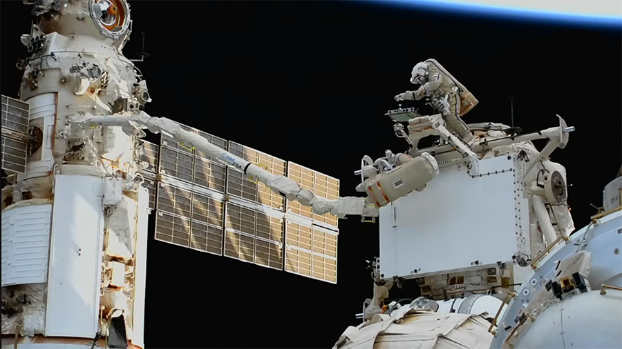 Cosmonauts Sergey Prokopyev and Dmitri Petelin work outside the space station during a spacewalk today to move a radiator from the Rassvet module to the Nauka module. Credit: NASA TV