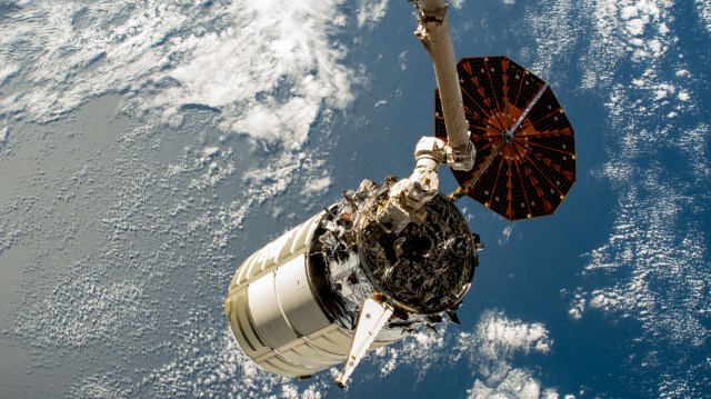 The Canadarm2 robotic arm grips Northrop Grumman’s Cygnus space freighter as the International Space Station orbits 262 miles above the north Atlantic Ocean.