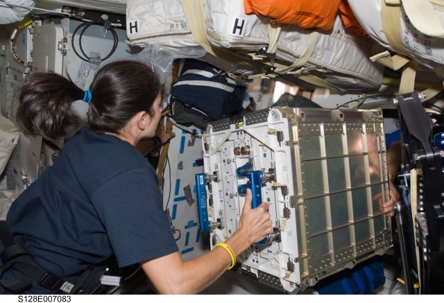 image of an astronaut relocating equipment inside the space station