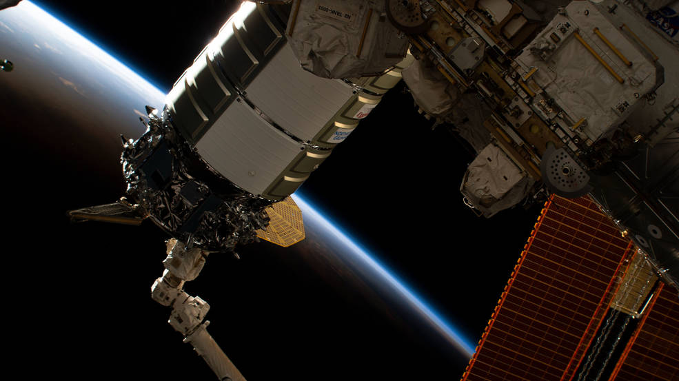 The Northrop Grumman Cygnus space freighter is pictured in the grip of the Canadarm2 robotic arm as ground controllers remotely install the cargo craft to the International Space Station's Unity module. 