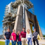 Student interns standing in front of Fred Haise Test Stand