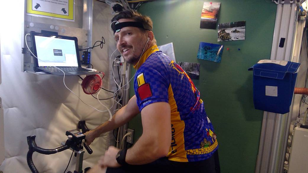 A HERA crew members takes a spin on a stationary bicycle during an exercise session in the habitat.